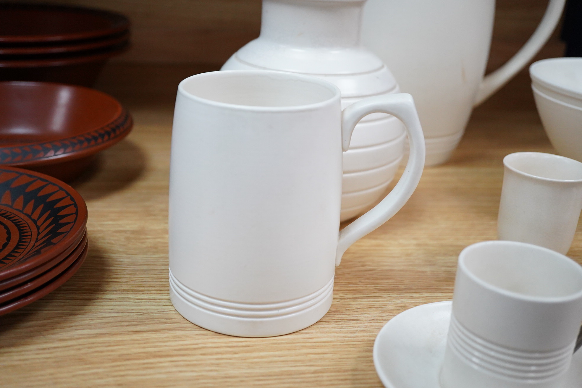 Keith Murray for Wedgwood, moonstone bowl, vase, jug, two mugs, coffee cups and small vase, largest 21cm high